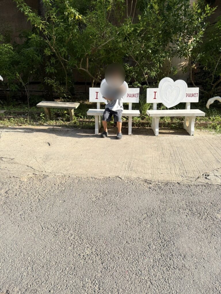 I PHUKET 벤치에 앉아 브이를 하는 아이